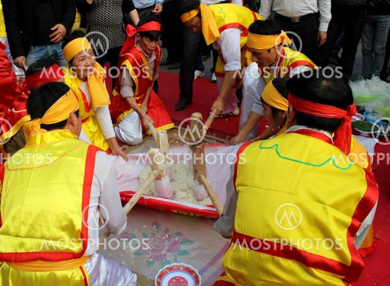 People in traditional costume exam to make round sticky...