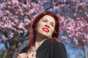Woman with cherry flowers surrounded by blossoming trees...