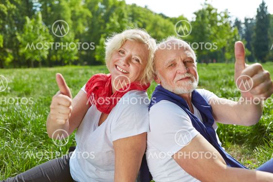 Happy senior couple holding thumbs up