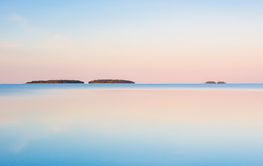Morning light illuminates still Lake Vanern in Sweden...