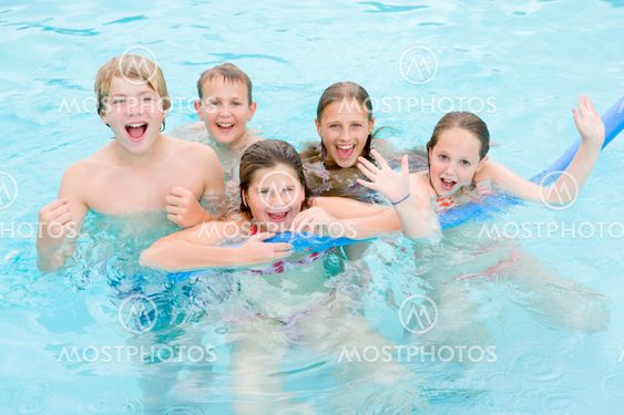 Five young friends in swimming pool playing and smiling