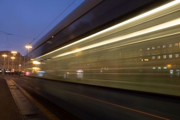 Tram passing by in the city at dusk with light trails