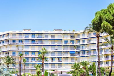 Daylight view to yellow hotel building and green trees