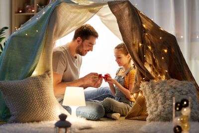 family playing tea party in kids tent at home