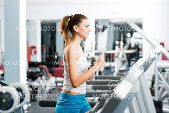attractive young woman runs on a treadmill