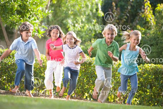 Five young friends running outdoors smiling