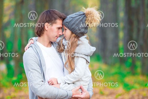 Little adorable girl with happy dad in autumn park outdoors
