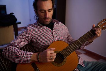 Man playing an acoustic guitar in a cozy indoor environment