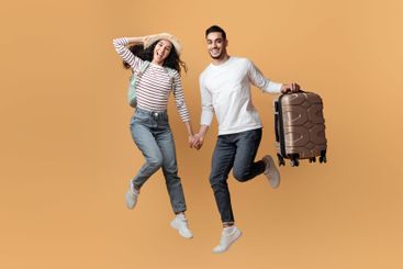 Active Travel Concept. Joyful Arab Couple Jumping With...