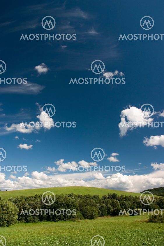 Summer cloudscape and green meadows