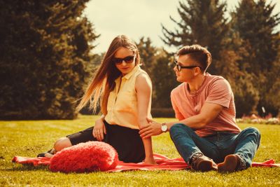 Moody girl with boyfriend in park. 