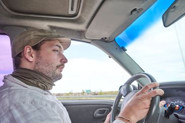Side portrait of a man traveling by car, concentrating...