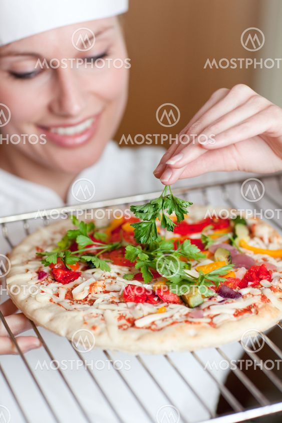 Beaautiful female chef preparing a pizza