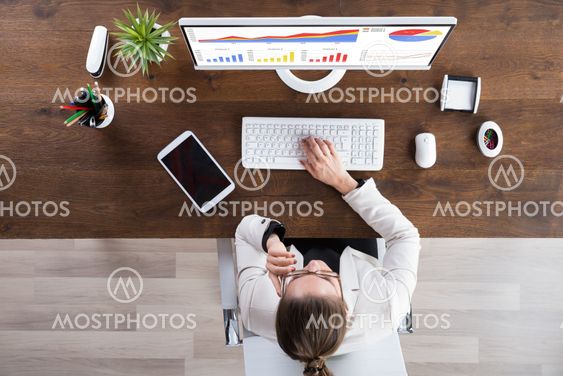 Businesswoman Looking At Graphs On Computer