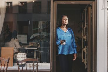 Female business professional holding coffee cup while...