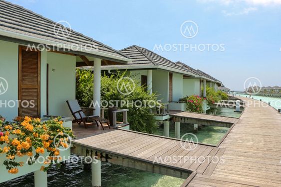 row of water bungalows on a tropical island - travel background