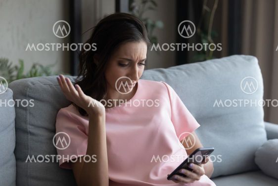 Close up unhappy Arabian woman looking at phone screen