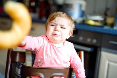 Cute little baby girl eating bread. Adorable child...
