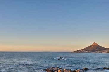Mountain, sunset and blue sky at sea outdoor on holiday,...
