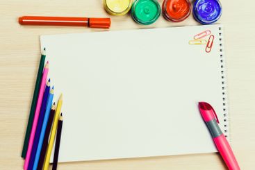 Creative workspace with colorful art supplies and blank...