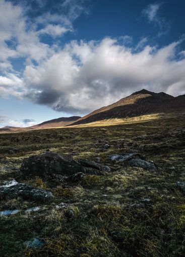 Dramatic landscape of hills under a dynamic sky at dusk...