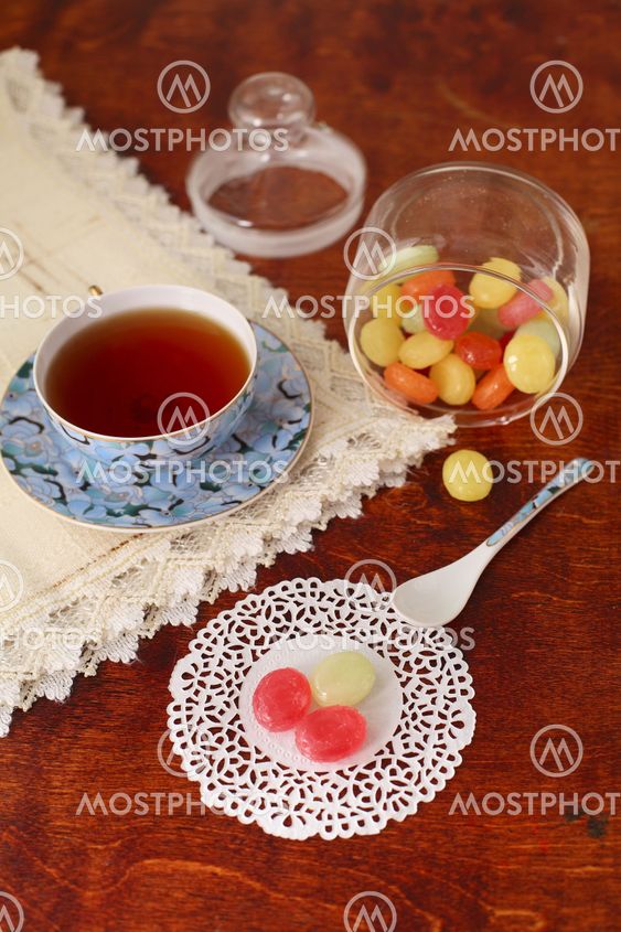 Tea with coloured sugar candies in a glass can