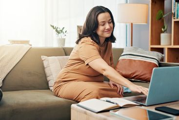 Pregnant woman, smile and typing on laptop at house for...