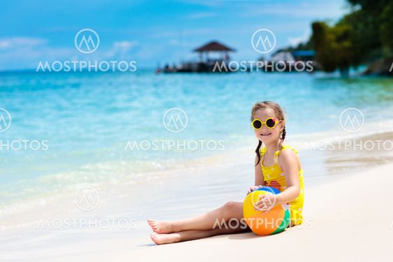 Kids play on tropical beach. Sand and water toy.