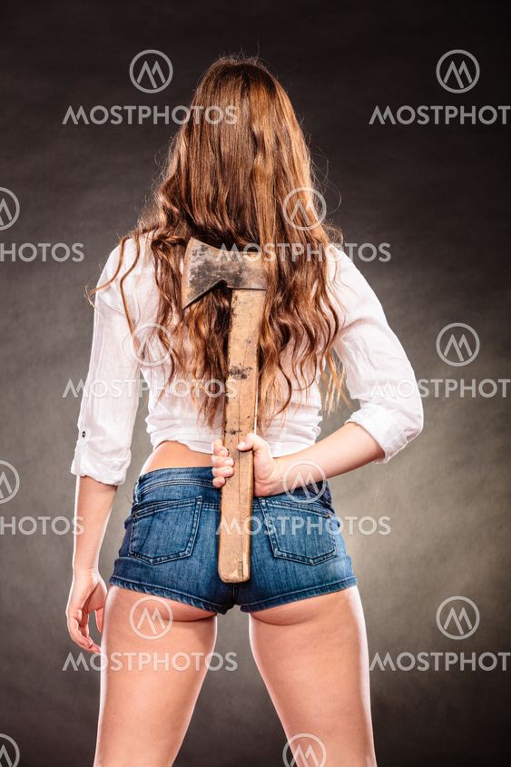 Strong woman feminist holding axe behind back.