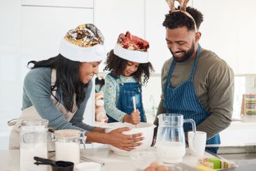 Christmas, parents and daughter with baking in kitchen...