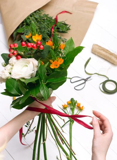 Female florist making beautiful bouquet at flower shop