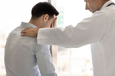 Compassionate male doctor telling hard serious diagnosis...