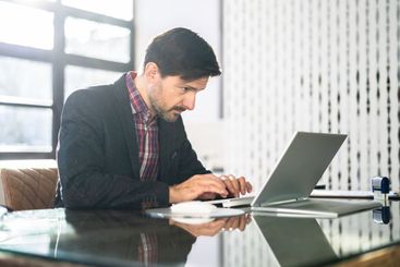 Man Sitting In Bad Posture Working On Computer