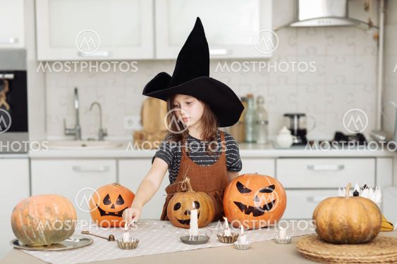 Happy halloween. Cute little girl in witch costume with...