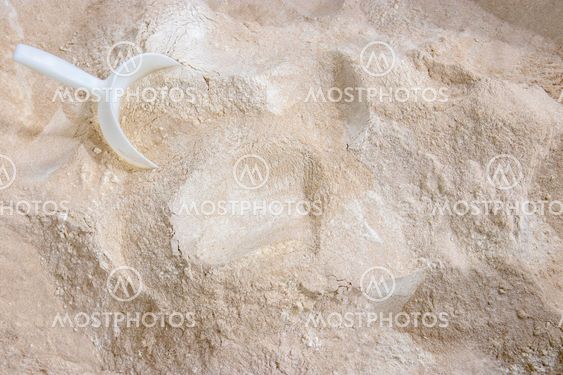 Mixed flour varieties and a plastic shovel seen from above