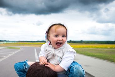 Sweet Laughing Baby Boy On Mother'S Shoulders