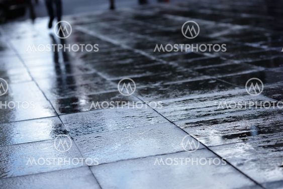 Silhouettes on wet road tiles