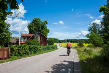 Picturesque rural landscape of Scandinavia, Man cycling