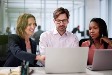 Smiling diverse team of businesspeople collaborates happily