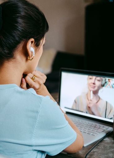 Female freelancer on video call with coworker over laptop...