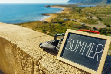 Black board with word summer against sea coast