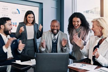 Business people, laptop and celebration meeting with...