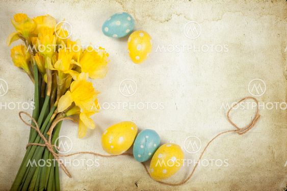 Easter background with painted eggs and blooming daffodils