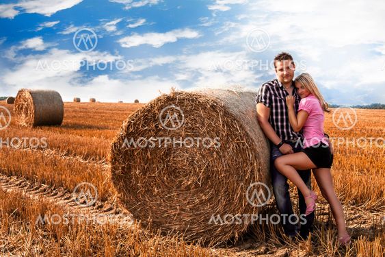 Loving attractive couple with hay bale