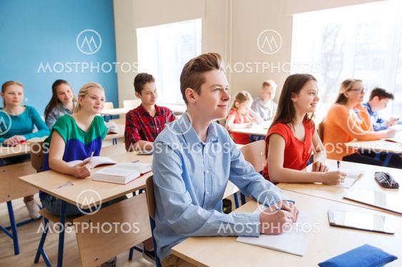 group of students with notebooks at school lesson