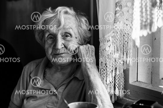 Black-and-white portrait of an elderly woman in her home.