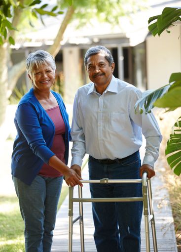 Senior couple, walking frame and outdoor with smile,...