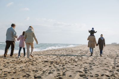 multigenerational family walking on seashore