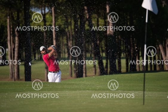 golfer hitting a sand bunker shot