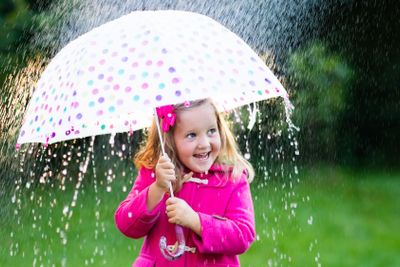 Little girl with umbrella in the rain